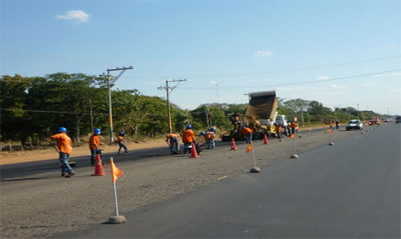 Workers applying Asphalt to a roadway image